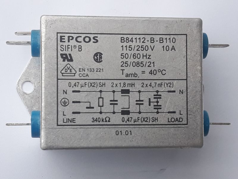Dieser Alt-Text wurde noch nicht überprüft.
<ol>
<li>
<p>Kurze Zusammenfassung:
Rechteckiges, silbernes EPCOS-Bauteil im Metallgehäuse mit aufgedruckten technischen Daten und Schaltbild; an beiden Seiten ragen je zwei Anschlüsse durch blaue Isolatoren heraus.</p>
</li>
<li>
<p>Detaillierte Beschreibung:
Das Foto zeigt frontal ein graues/silbernes Metallgehäuse mit abgerundeten Kanten und einer seitlichen Befestigungslasche mit rundem Loch links. Links und rechts sind jeweils zwei flache Anschlussfahnen zu sehen, die durch blaue Isolatoren geführt werden. Auf der Gehäusefront steht oben links „EPCOS“ und „SIFI B“. Oben rechts sind Typ- und Leistungsdaten aufgedruckt: „B84112-B-B110“, „115/250V 10A“, „50/60 Hz“, „25/085/21“, „T amb. = 40°C“. Darunter befinden sich mehrere Prüf- und Normzeichen (u. a. ein „UR“-Symbol, ein rundes „CSA“-ähnliches Zeichen und ein Dreieck mit „VDE“), sowie der Text „EN 133 221 CCA“. In einem eingerahmten Feld ist ein Schaltbild mit Beschriftungen dargestellt: links „LINE“ mit „N“ und „L“, rechts „LOAD“ mit „N“ und „L“; eingezeichnet sind Kondensatoren und Drosseln, beschriftet u. a. mit „0,47 µF (X2) SH“, „2 x 1,8 mH“, „2 x 4,7 nF (Y2)“ und ein Widerstand „340 kΩ“. Links neben dem Schaltbild ist das Erdungssymbol abgebildet. Unten mittig steht „01.01“. Die Oberfläche wirkt matt und leicht gebürstet; Hintergrund ist neutral hell."></p>
 <figcaption>Abbildung NEA-10.14.5:  Funkentstörfilter Filter für ein Schaltnetzteil</figcaption>
</li>
</ol>
</figure>
<figure class=