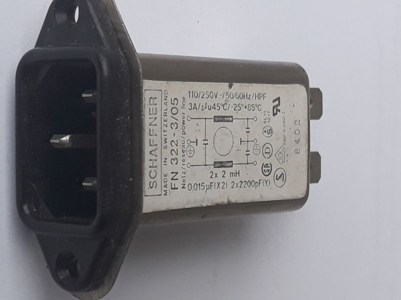 Dieser Alt-Text wurde noch nicht überprüft.
<ol>
<li>
<p>Kurzzusammenfassung: Ein flanschmontierbarer IEC-Netzeinbaustecker mit integriertem Filter von Schaffner liegt auf weißem Hintergrund.</p>
</li>
<li>
<p>Detaillierte Beschreibung: Links ist die schwarze Kunststofffront mit einem dreipoligen IEC-C14-Einlass und zwei Befestigungsbohrungen zu sehen, daran schließt sich ein längliches Metallgehäuse an. Auf der Oberseite klebt ein weißes Typenschild mit der Aufschrift „SCHAFFNER – MADE IN SWITZERLAND – FN 322-…“, mit Angaben wie „110/250 V~ 50/60 Hz“ und „3 A“, einem kleinen Schaltbild (mit Beschriftungen „2× 2 mH“, „0,015 µF (X2)“ und „2× 2200 pF (Y)“) sowie mehreren Prüf- und Zulassungszeichen. Rechts ragen zwei Flachsteckkontakte aus dem Gehäuse heraus; an der Seite ist eine Zahl (z. B. „8402“) aufgedruckt. Die Aufnahme ist leicht seitlich gedreht, die Farben sind Schwarz, Grau und Weiß, mit leichten Gebrauchsspuren am Gehäuse."></p>
 <figcaption>Abbildung NEA-10.14.6:  Filter direkt am $230&nbsp;V$ AC Spannungseingang</figcaption>
</li>
</ol>
</figure>
</aside>

                        </div>
                    </article>
                </main>

                <aside class=